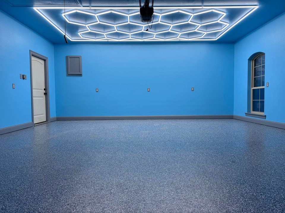 Blue-walled garage with speckled floor and geometric ceiling lighting.